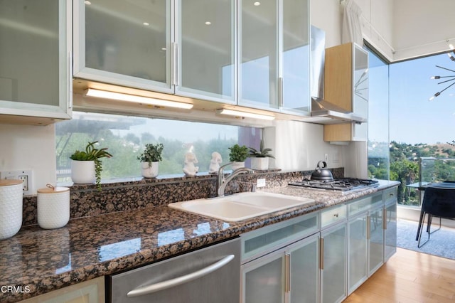 1196 Montecito Dr, Los Angeles, CA 90031 - kitchen with appliances with stainless steel finishes, a sink, dark stone countertops, light wood finished floors, and glass insert cabinets