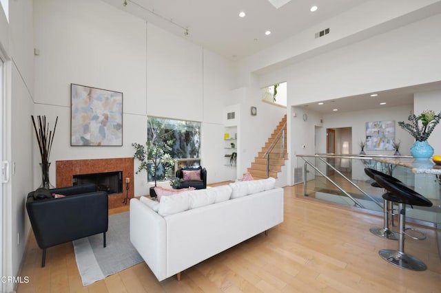 1196 Montecito Dr, Los Angeles, CA 90031 - living room featuring a high ceiling, a fireplace, light wood-type flooring, plenty of natural light, and stairs