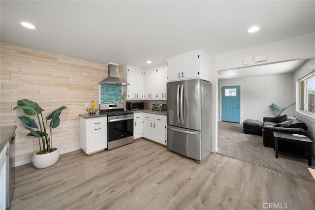 870 El Moro Ave, Los Osos, CA 93402 - kitchen featuring appliances with stainless steel finishes, wall chimney range hood, white cabinets, light wood-style floors, and recessed lighting