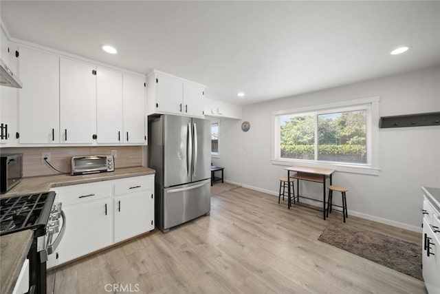 870 El Moro Ave, Los Osos, CA 93402 - kitchen featuring stainless steel appliances, baseboards, light wood-style flooring, light countertops, and white cabinets