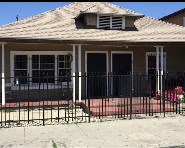 133135 E 54th St, Los Angeles, CA 90011 - view of front of home with a fenced front yard, a porch, and a shingled roof