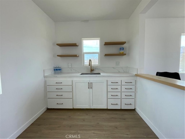 6663 Sage Ave Unit 29, Palms, CA 92277 - kitchen featuring a sink, open shelves, wood finished floors, and white cabinetry