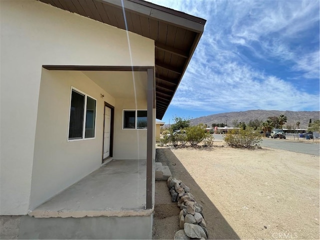 6663 Sage Ave Unit 29, Palms, CA 92277 - view of property exterior featuring a mountain view, stucco siding, and a patio