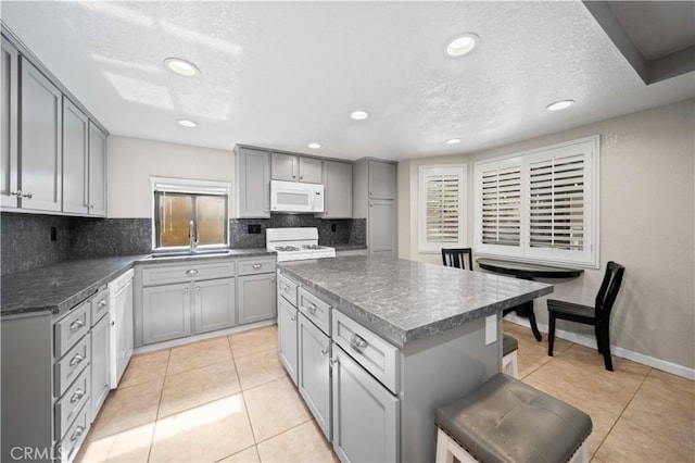 43007 Pearlwood Dr, Lancaster, CA 93536 - kitchen with white appliances, gray cabinets, a sink, decorative backsplash, and recessed lighting
