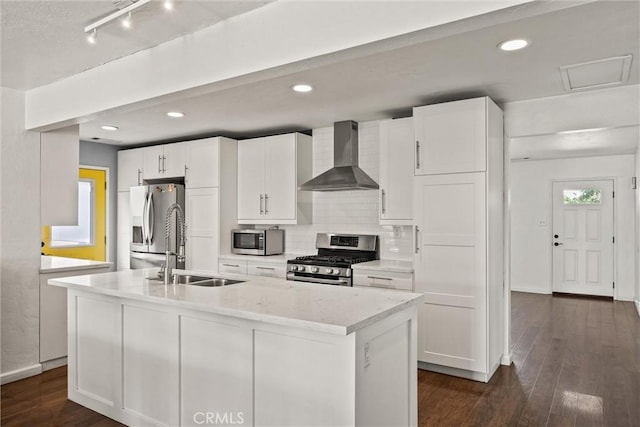 417 Jefferson St, Willows, CA 95988 - kitchen featuring appliances with stainless steel finishes, wall chimney range hood, a sink, an island with sink, and white cabinetry