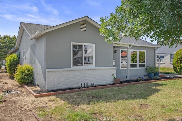 417 Jefferson St, Willows, CA 95988 - view of front of property with brick siding, stucco siding, a front yard, and a shingled roof