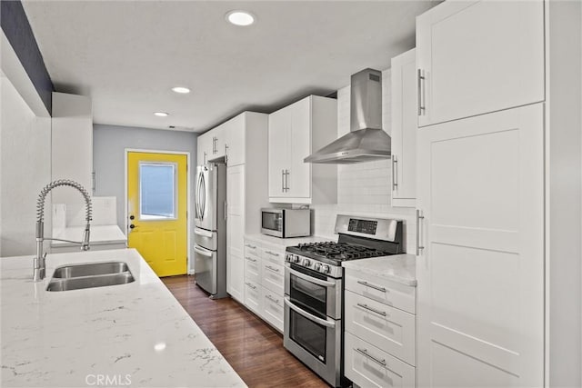 417 Jefferson St, Willows, CA 95988 - kitchen with wall chimney range hood, appliances with stainless steel finishes, a sink, dark wood finished floors, and light stone counters