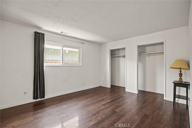 417 Jefferson St, Willows, CA 95988 - unfurnished bedroom featuring two closets, wood finished floors, and baseboards