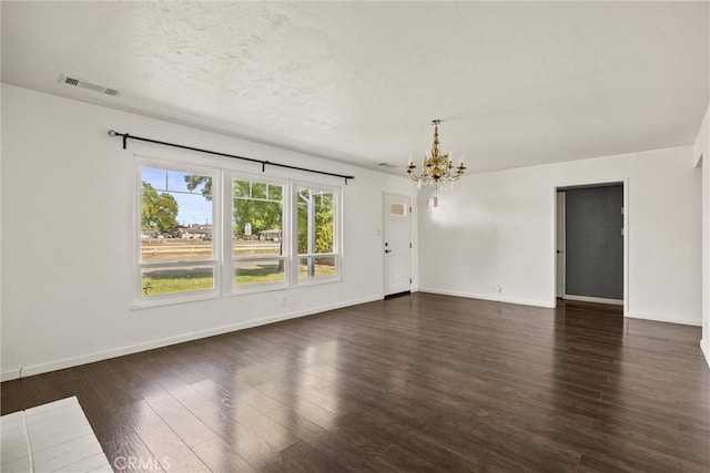 417 Jefferson St, Willows, CA 95988 - unfurnished living room with a chandelier, dark wood-type flooring, baseboards, and a textured ceiling