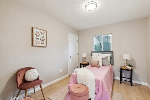 325 N 3rd Ave, Oakdale, CA 95361 - bedroom featuring light wood-style floors, baseboards, and a textured ceiling