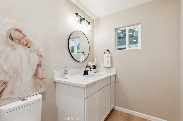 325 N 3rd Ave, Oakdale, CA 95361 - bathroom featuring vanity, toilet, baseboards, and wood finished floors
