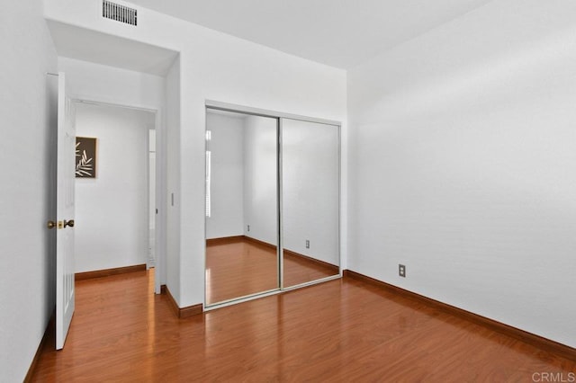 7254 Shoreline Dr Unit 131, San Diego, CA 92122 - unfurnished bedroom featuring wood finished floors, a closet, and baseboards