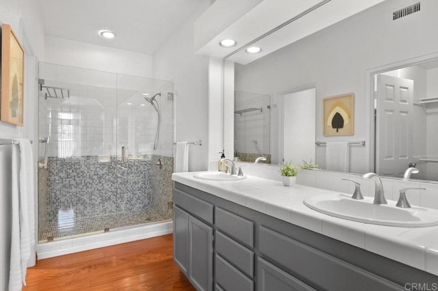 7254 Shoreline Dr Unit 131, San Diego, CA 92122 - bathroom featuring a shower stall, double vanity, wood finished floors, and recessed lighting