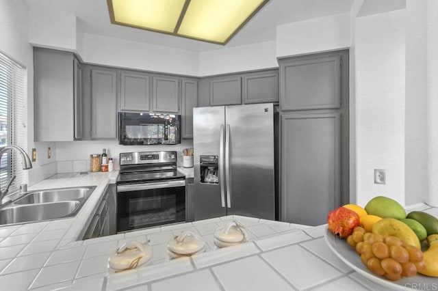 7254 Shoreline Dr Unit 131, San Diego, CA 92122 - kitchen featuring stainless steel appliances, a sink, gray cabinetry, and tile counters