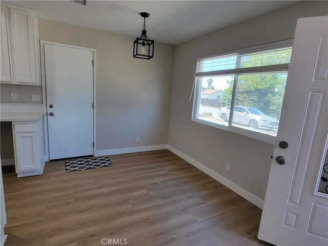 15475 Shadow Mountain Ln, Lake Elsinore, CA 92530 - unfurnished dining area featuring light wood-style flooring and baseboards
