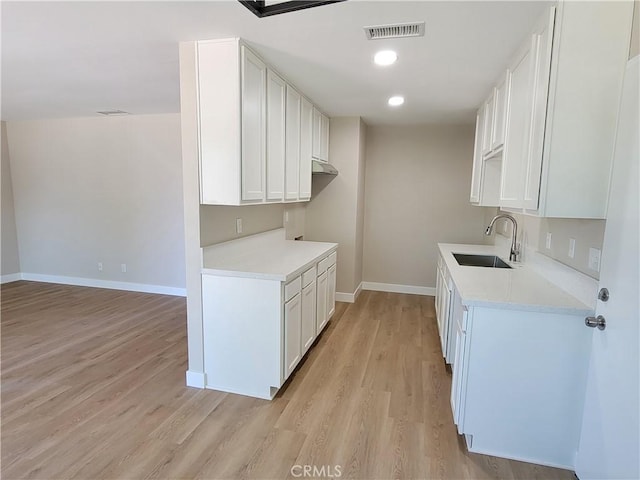 15475 Shadow Mountain Ln, Lake Elsinore, CA 92530 - kitchen with light wood-type flooring, light countertops, white cabinets, and recessed lighting