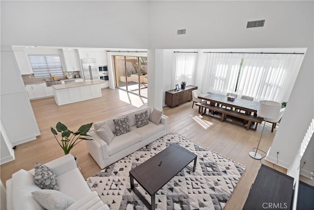113 Imagination Trl, Irvine, CA 92620 - living room with a towering ceiling, light wood-type flooring, and plenty of natural light