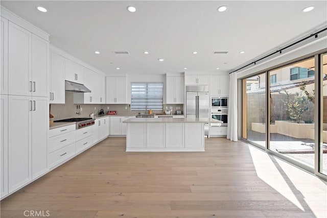 113 Imagination Trl, Irvine, CA 92620 - kitchen with built in appliances, white cabinetry, light countertops, recessed lighting, and tasteful backsplash