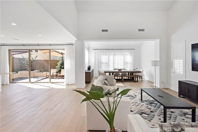 113 Imagination Trl, Irvine, CA 92620 - living room with a towering ceiling, light wood-style floors, plenty of natural light, and baseboards