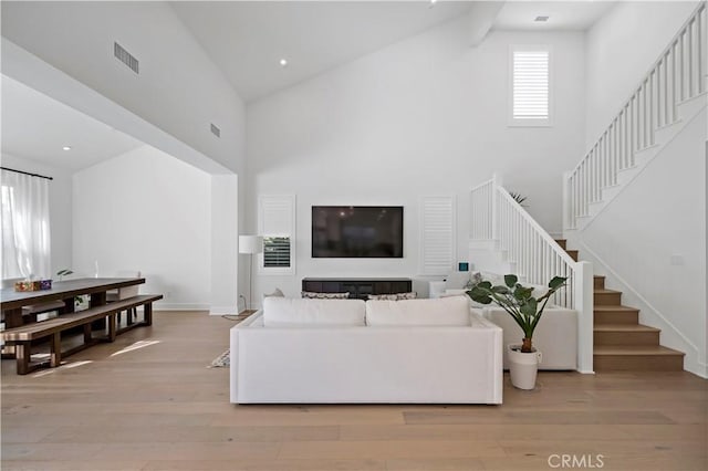 113 Imagination Trl, Irvine, CA 92620 - living area featuring high vaulted ceiling, stairs, light wood finished floors, and baseboards