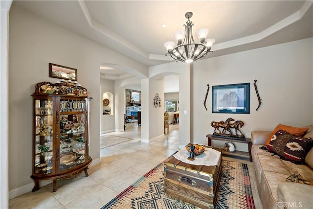 10204 Mount Olympus Valley Rd, Fallbrook, CA 92028 - living room featuring arched walkways, light tile patterned floors, a raised ceiling, a chandelier, and baseboards