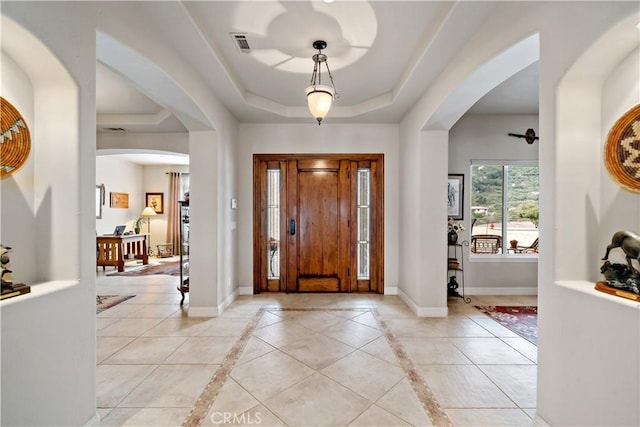 10204 Mount Olympus Valley Rd, Fallbrook, CA 92028 - entryway featuring arched walkways, a raised ceiling, baseboards, and inlaid floor details