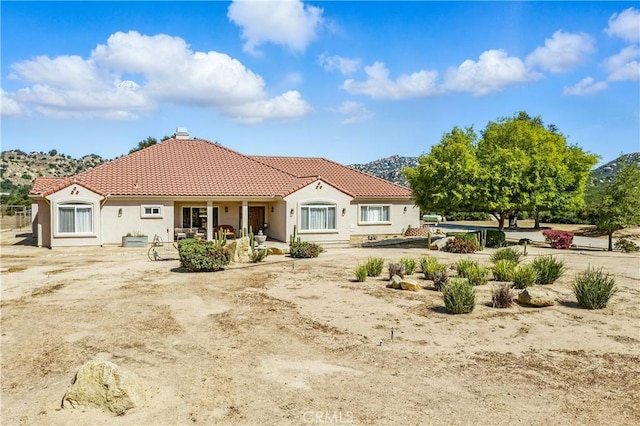10204 Mount Olympus Valley Rd, Fallbrook, CA 92028 - back of house with a tile roof, stucco siding, a chimney, and a porch