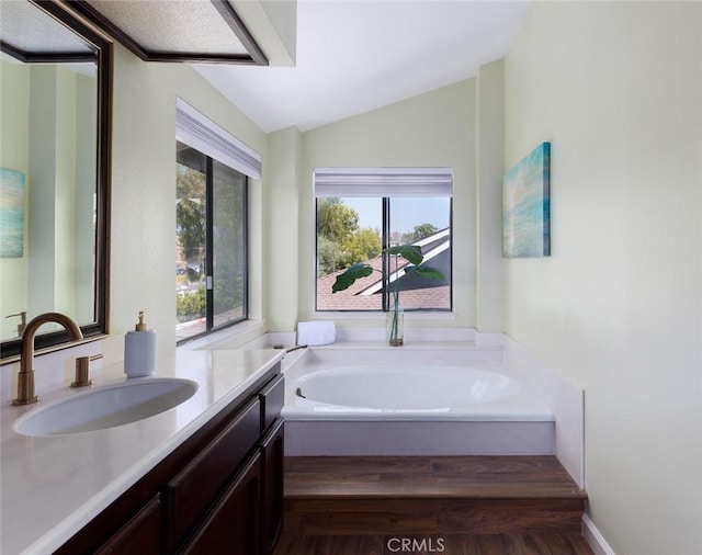 5941 E Valley Forge Dr, Orange, CA 92869 - full bathroom featuring vanity, a garden tub, vaulted ceiling, and wood finished floors