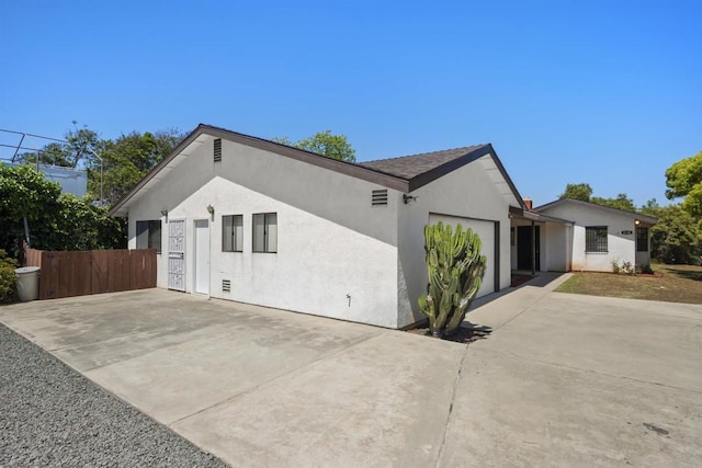 2125 Prospect St, National City, CA 91950 - view of side of home with concrete driveway, a garage, and stucco siding