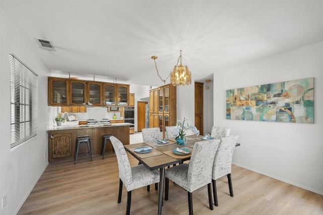 2125 Prospect St, National City, CA 91950 - dining area with a chandelier, light wood-style floors, and baseboards