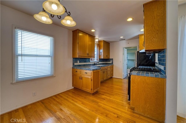 273 Almond St, San Luis Obispo, CA 93405 - kitchen featuring brown cabinetry, a sink, tasteful backsplash, light wood finished floors, and recessed lighting