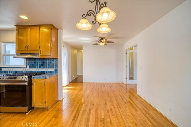 273 Almond St, San Luis Obispo, CA 93405 - kitchen with stainless steel range with gas cooktop, under cabinet range hood, ceiling fan, brown cabinets, and backsplash