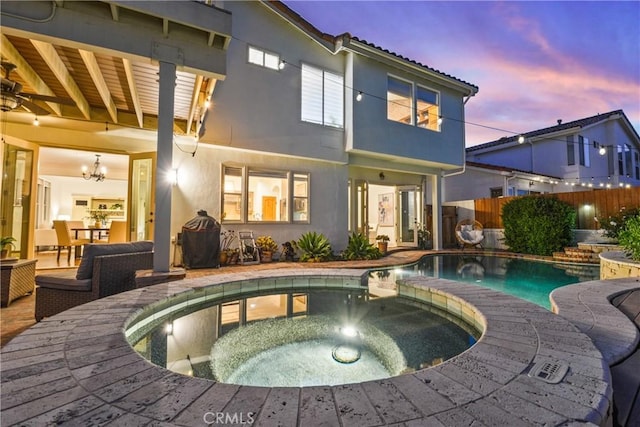 112 Del Cabo, San Clemente, CA 92673 - back of property at dusk with stucco siding and a pool with connected hot tub