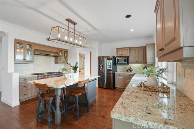 112 Del Cabo, San Clemente, CA 92673 - kitchen featuring stainless steel appliances, wall chimney range hood, crown molding, backsplash, and a center island