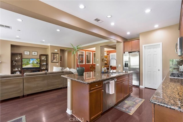 7151 Stockton Dr, Eastvale, CA 92880 - kitchen with appliances with stainless steel finishes, dark stone countertops, open floor plan, a kitchen island with sink, and a sink