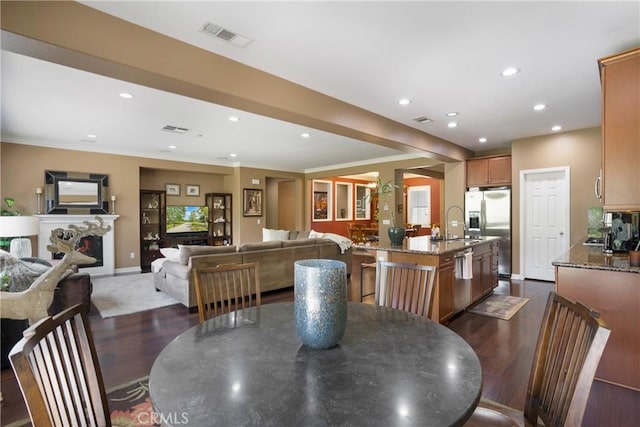 7151 Stockton Dr, Eastvale, CA 92880 - dining area featuring dark wood-style flooring, recessed lighting, crown molding, and baseboards
