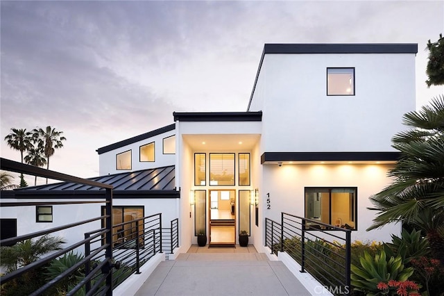 152 El Levante, San Clemente, CA 92672 - back of house at dusk featuring a standing seam roof, stucco siding, and metal roof