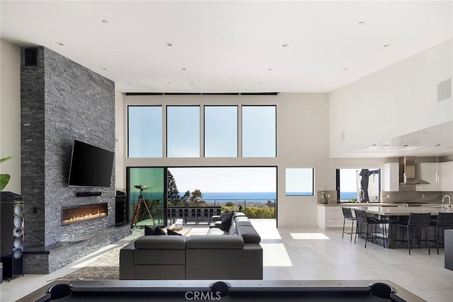 152 El Levante, San Clemente, CA 92672 - living room featuring a towering ceiling, a stone fireplace, and light tile patterned floors