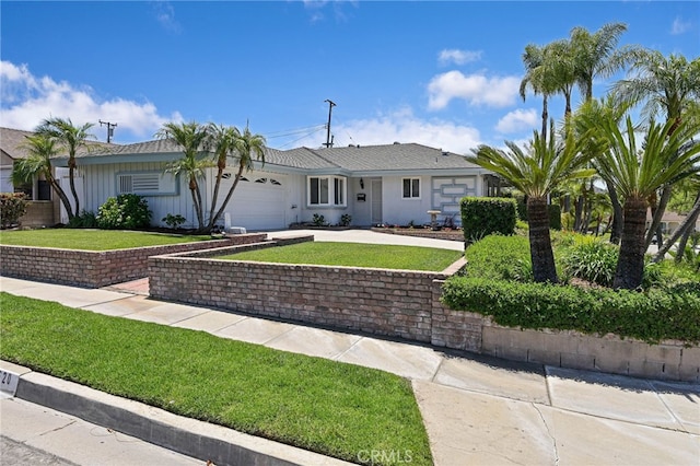 2620 W Cobblestone Rd, La Habra, CA 90631 - single story home featuring a front yard, a garage, driveway, and board and batten siding