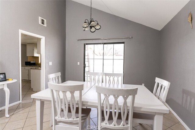 38633 Angele Trumpet Ct, Palmdale, CA 93550 - dining area with light tile patterned floors, a chandelier, high vaulted ceiling, and baseboards