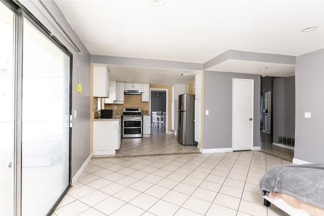38633 Angele Trumpet Ct, Palmdale, CA 93550 - kitchen featuring appliances with stainless steel finishes, under cabinet range hood, baseboards, white cabinetry, and open floor plan