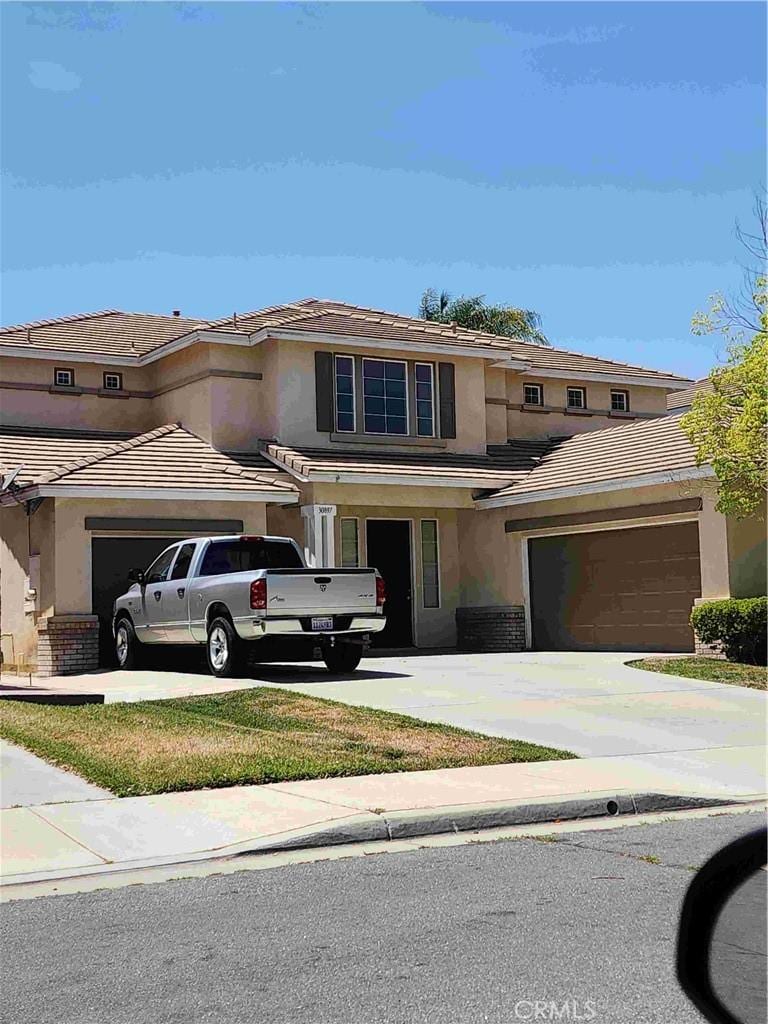 30897 Anderson Cir, Menifee, CA 92584 - traditional-style house featuring concrete driveway, a tile roof, stucco siding, and an attached garage
