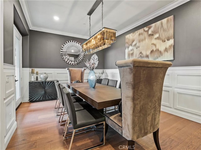 22385 Midtown Ct, Saugus, CA 91350 - dining area with crown molding, a decorative wall, a chandelier, a wainscoted wall, and wood finished floors