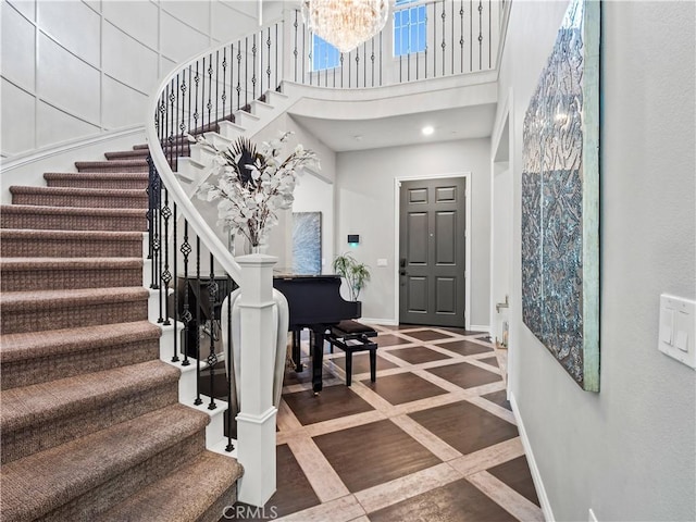 22385 Midtown Ct, Saugus, CA 91350 - entryway with inlaid floor details, baseboards, a high ceiling, stairway, and a chandelier