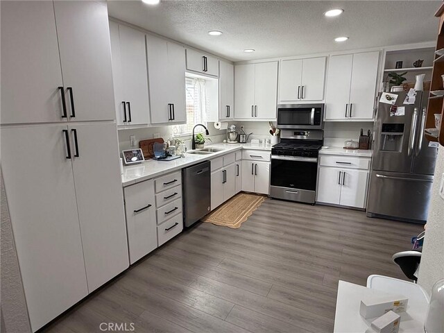 37098 San Bruno Ave, Barstow, CA 92311 - kitchen with stainless steel appliances, a sink, light countertops, recessed lighting, and white cabinets