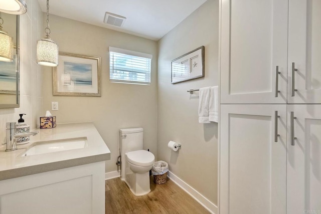 295 Chinquapin Ave, Carlsbad, CA 92008 - bathroom featuring baseboards, wood finished floors, toilet, and vanity