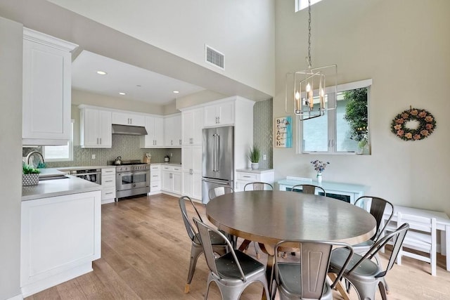 295 Chinquapin Ave, Carlsbad, CA 92008 - dining area with plenty of natural light, light wood-style floors, a high ceiling, a chandelier, and recessed lighting