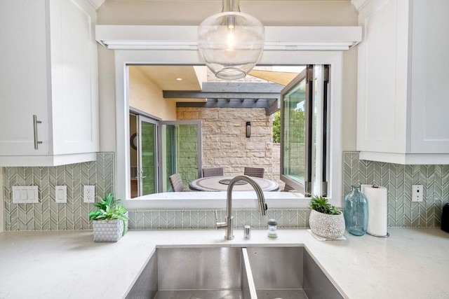 295 Chinquapin Ave, Carlsbad, CA 92008 - kitchen view of a sink, white cabinetry, backsplash, and light stone counters