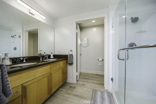 411 W Seaside Way Unit 1103, Long Beach, CA 90802 - full bathroom featuring wood finished floors, a shower stall, double vanity, and baseboards