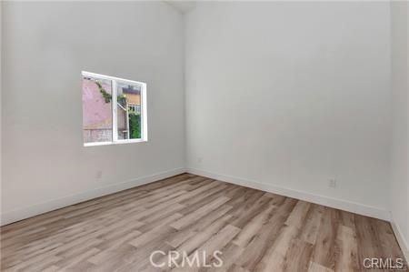8418 S Main St, Los Angeles, CA 90003 - unfurnished room with wood finished floors and baseboards